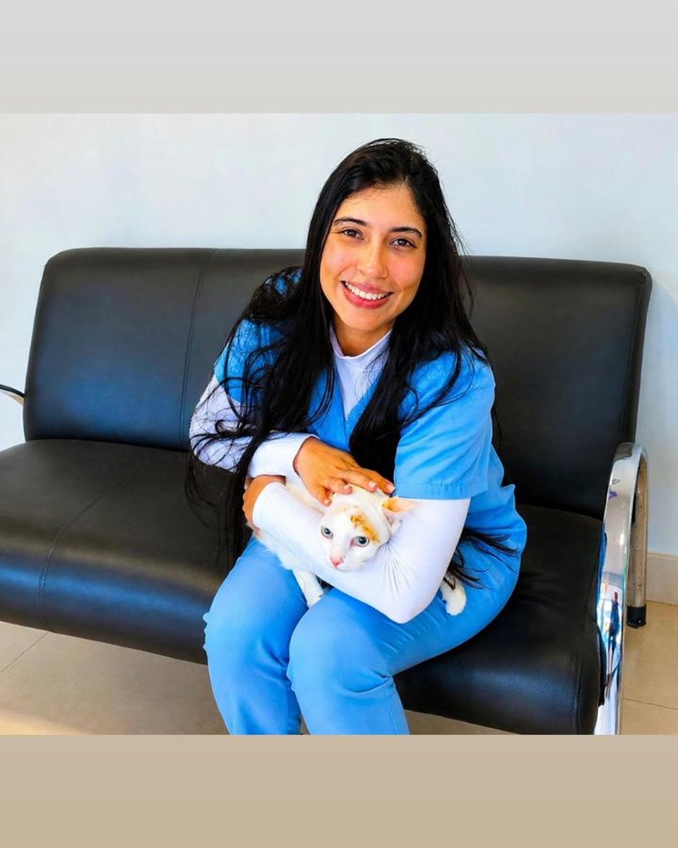 Dra. Ana Cláudia com um gato branco no colo.