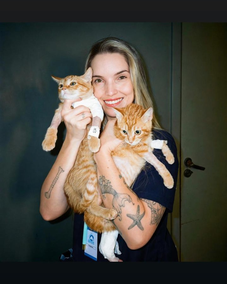 Dra. Jaiane Machado com dois gatos no colo.